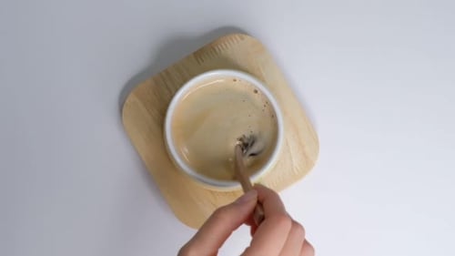 Top View of Person Hand Steering Coffee in a Cup with Spoon Breakfast Morning of a Cup Hot Black