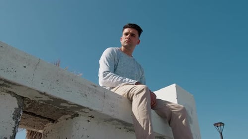 Young Man Sitting, Contemplating Urban View