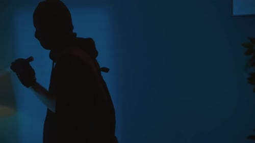 Silhouetted Figures with Flashlights in Dark Interior