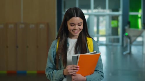 Young Woman Smiling in School Hallway with Books