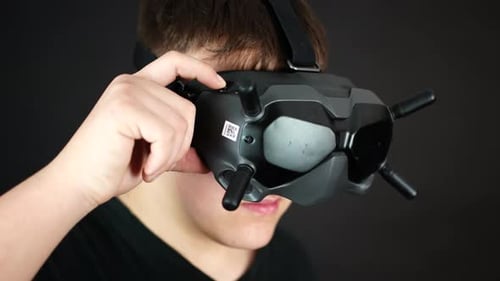 Close Up of Young Man Touching Buttons on VR Goggles Headset