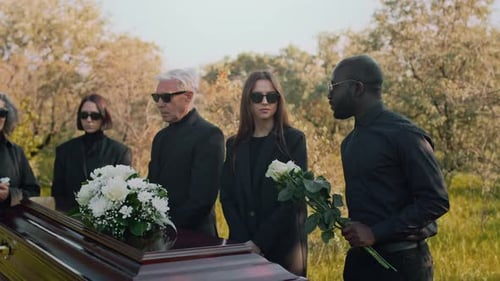 Man Coming to Outdoor Funerals with White Flowers