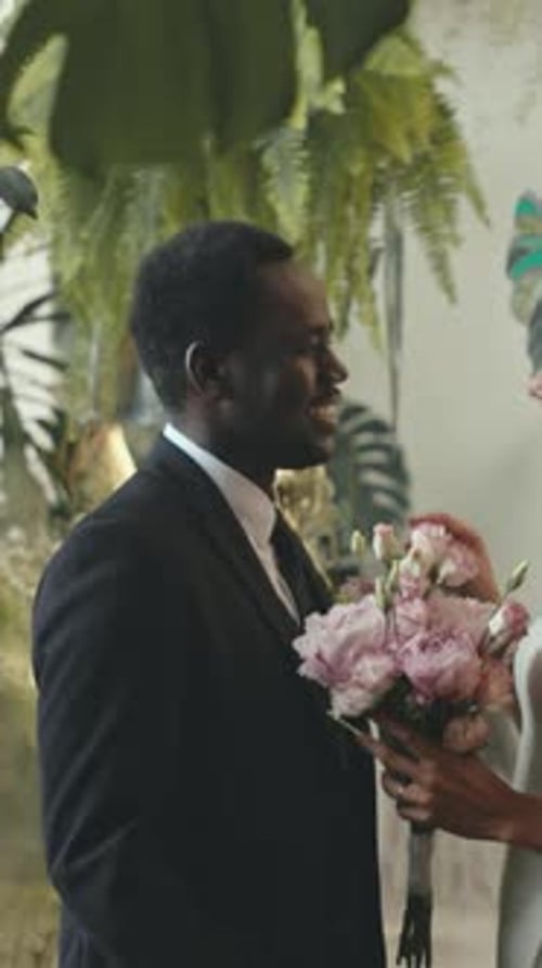 Wedding Couple Embracing with Flowers Indoors