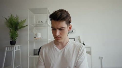 Young Man Listens to Lecture at Conference Making Notes