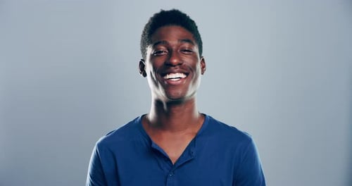 Smiling Young Adult Gesticulating Towards Camera