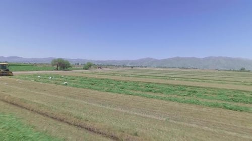 Farm Equipment Harvesting Crops in Rural Landscape