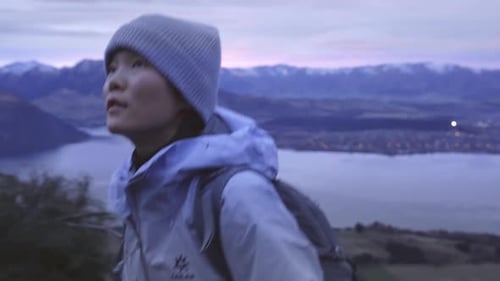 Asian Woman Hiker Across Lake Wanaka Overlooking Roys Peak In New Zealand. Close-up Shot