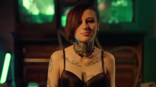 Woman With Tattoos and Piercings Poses Indoors