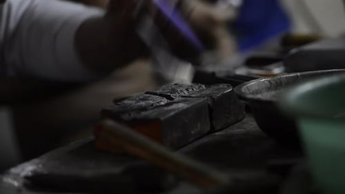 Juwelier bearbeitet und erhitzt eine kleine Metallplatte mit einer Lötlampe - Verfahren zur Herstellung eines Schmucks. -