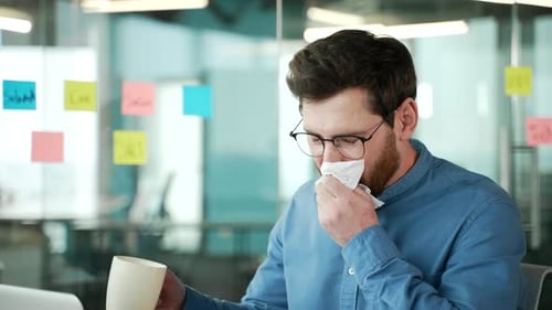 Sick Man Drinks Coffee in the Office
