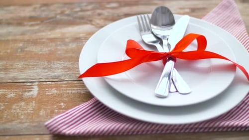 Table setting with utensils and red ribbon