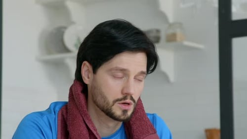 Sweaty Man Wipes Face and Drinks Water After Workout