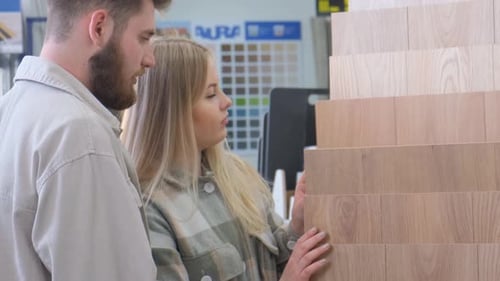 An Interested Family Chooses a Wooden Floor in a Hardware Store The Concept of Home Renovation