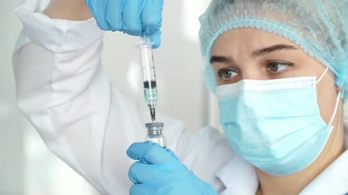 Medical Professional Drawing Vaccine Dose into Syringe