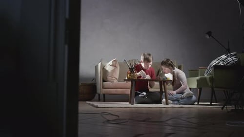 Siblings Do Arts and Crafts in Living Room