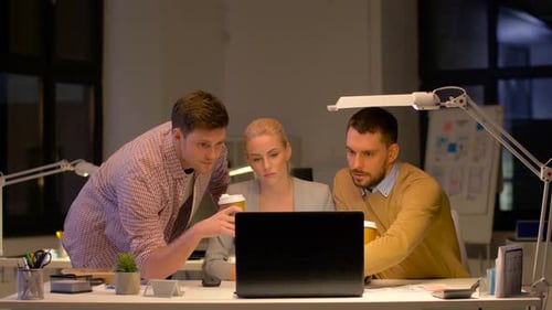 Business, People And Deadline Concept - Team With Laptop Computer And Coffee Working At Night Office
