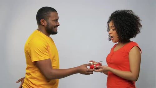 Man gives a gift to smiling woman
