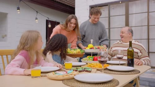 Multiracial family having fun and enjoying party outdoors in garden.