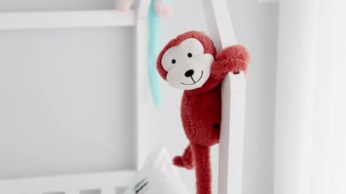 Red Plush Monkey Hanging from Crib