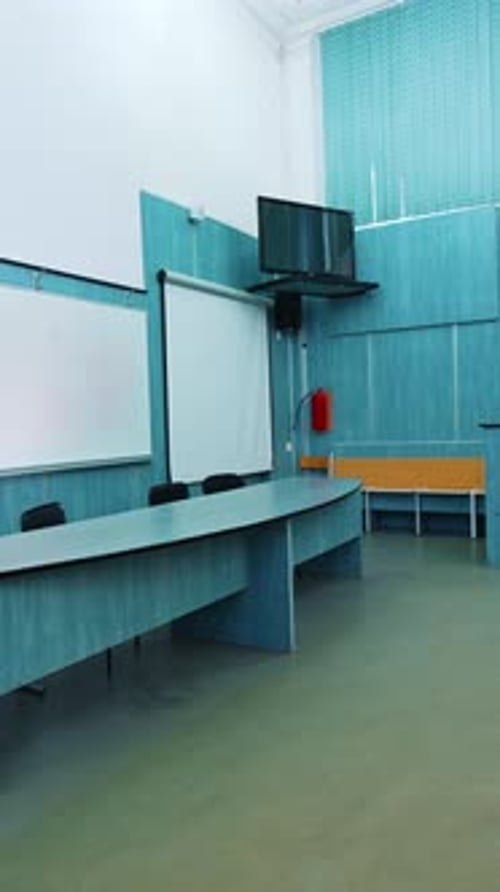 Modern interior of lecture hall. White board and presidium table in the university classroom.