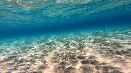 Vista submarina del fondo marino en Grecia, arena y agua azul opaca