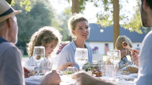 Family Having A Big Garden Party And Feasting Together.