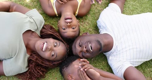 Happy Family Lying on Grass Together Smiling