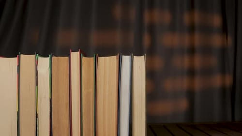 Hardcover Books Appearing One by One to Fill a Shelf
