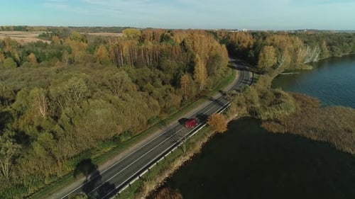 Vista aérea da estrada que atravessa a paisagem rural europeia à beira da grande água