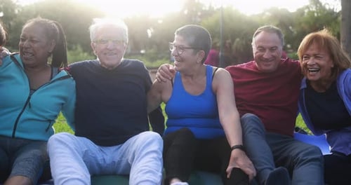 Multiracial senior people having fun after workout exercises outdoor with city park in background