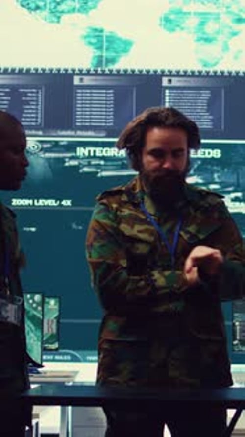 Adults Stand in Front of Large Screen With Maps