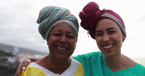 Happy African Mother and Daughter Smiling in Front of Camera with Beach