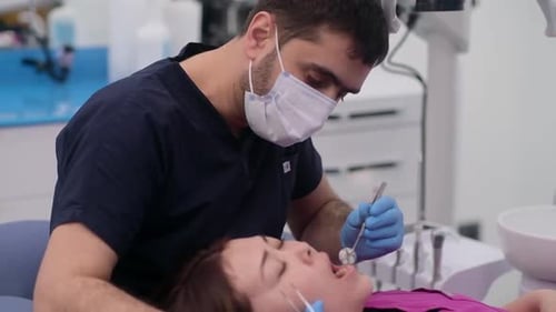 Dentist Examining Patient's Teeth in Clinic