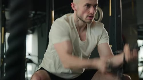 Athletic Man Working Out With Battle Ropes in Gym