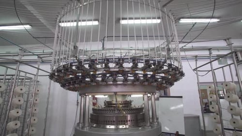 Backwards shot of large modern Textile Industry - Yarn Spools On Spinning Machine In A Factory Lab.