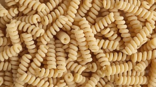 Papel de parede de massa de fubá sem glúten Macarrão cru em espiral a partir de farinha de milho e arroz girando