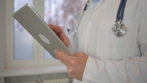 Close up of Doctor Using Tablet