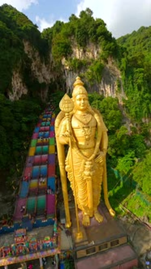 Vol cinématographique en drone FPV autour de la statue dorée de Murugan dans les grottes de Batu, en Malaisie