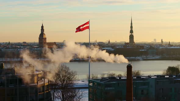 Latvian National Flag Waving at Sunrise with Old Riga in Background ...