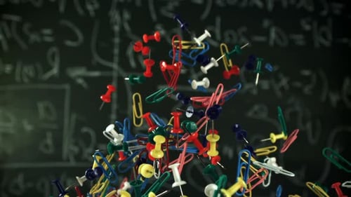 Different School Objects Fly and Fall Against the Background of the Blackboard Filmed on a Highspeed