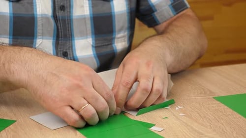 Man Creating Origami Box at Table