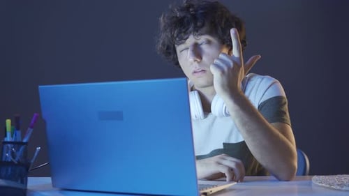 Man Types on Laptop Computer at Night