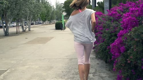 Young woman jogging in city park for fitness training in super slow motion