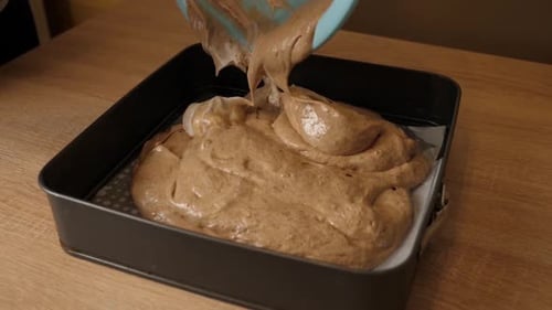 Pouring Cake Batter into Baking Pan at Home