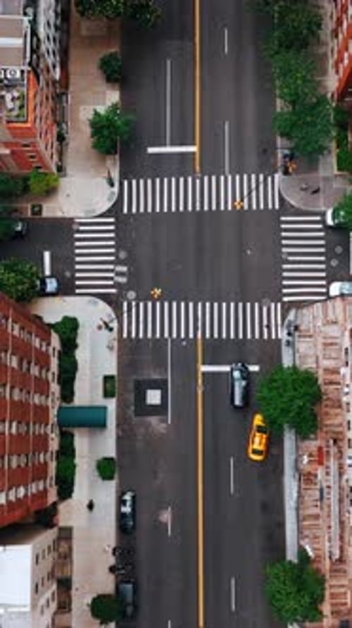 Going down over the usual crossroads in New York. View of building tops from above. Vertical video