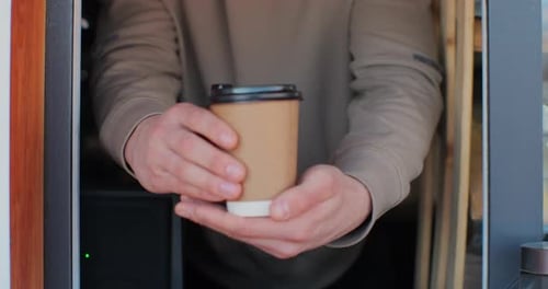 Close Up Male Hand Barista Giving Cup of Coffee to Camera and Smiling