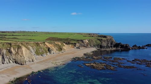 aerial view of the rocky coastline, beach and clear water in the South of Ireland in Summer time