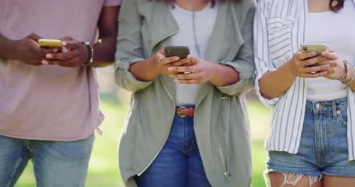 Three Friends Using Mobile Phones in the City
