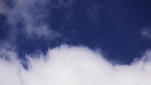 Un avion vole derrière le paysage nuageux