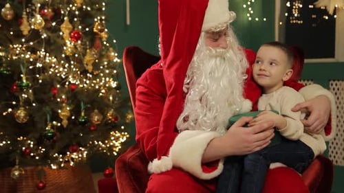 Boy With Santa By Christmas Tree Indoors